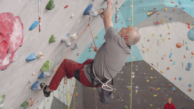 indoor climbing wall with hardware and male climber